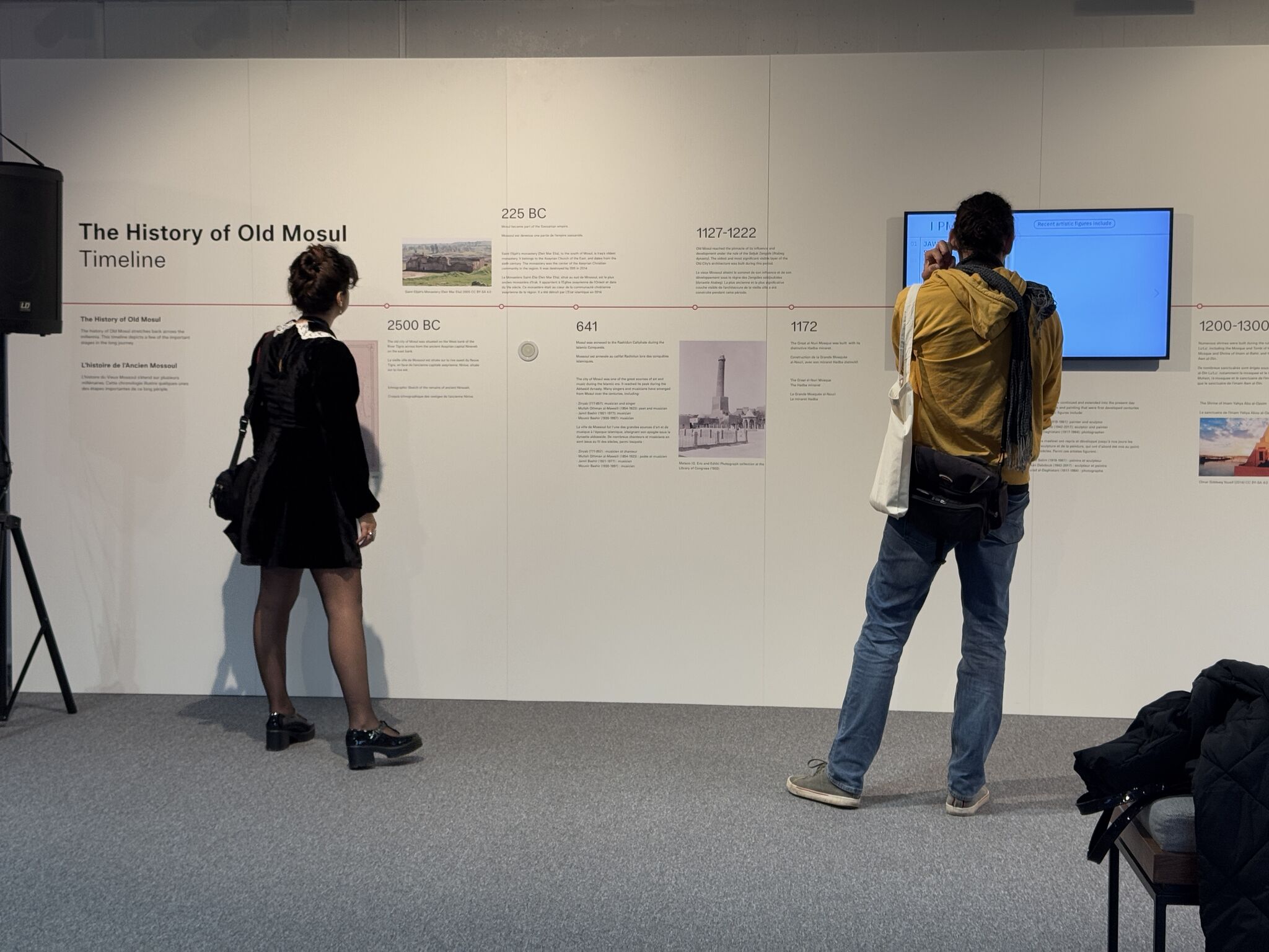 Two people look at a timeline of the History of Old Mosul