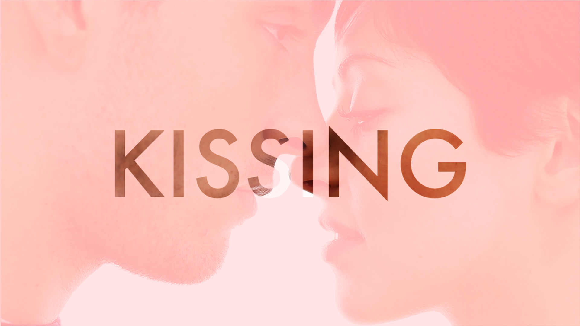 A photo of a couple standing close eough to kiss, with a pink treatment and with the Kissing logo superimposed