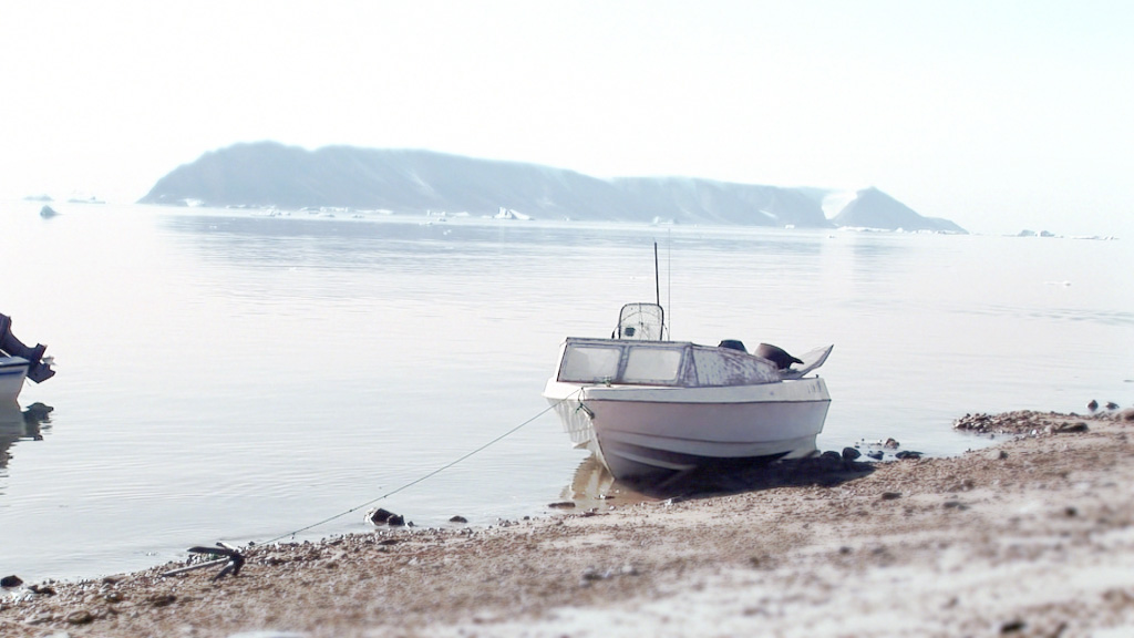A screenshot of a boat sitting on shore next to the sea
