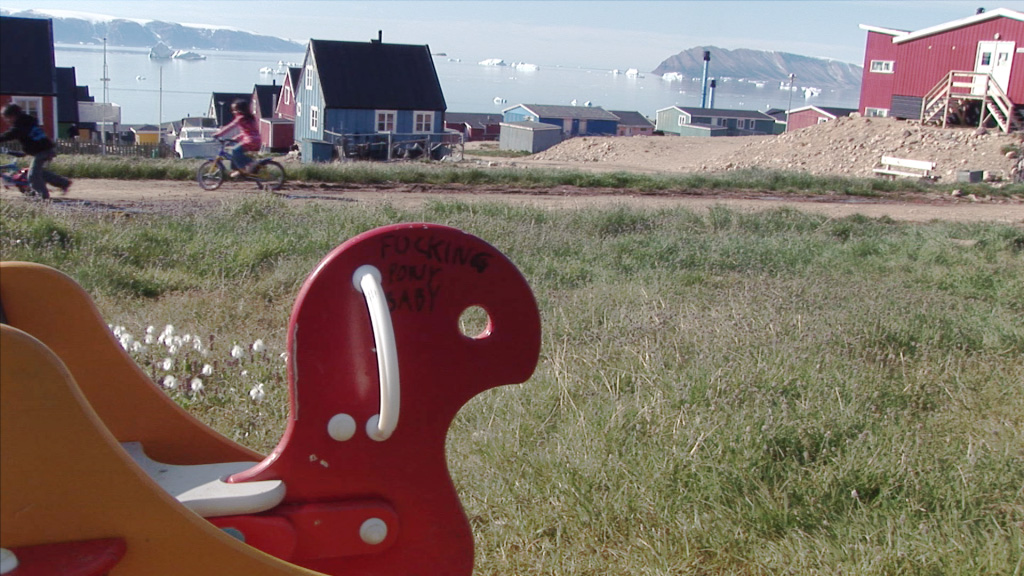 A screenshot of a childrens playground, with some graffiti scribbled on one of the objects