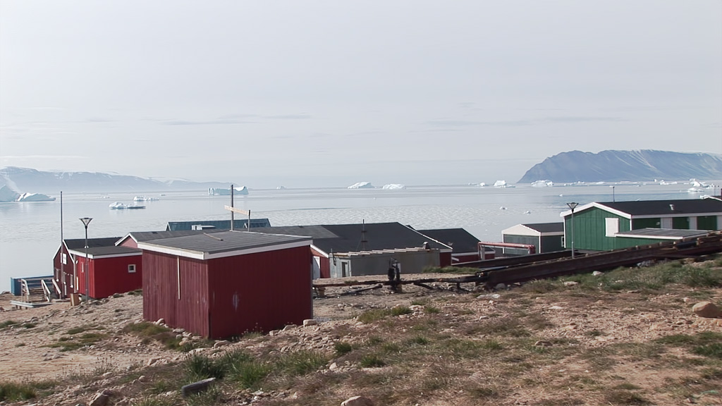 A screenshot of a greenlandic town, with the sea in the distance