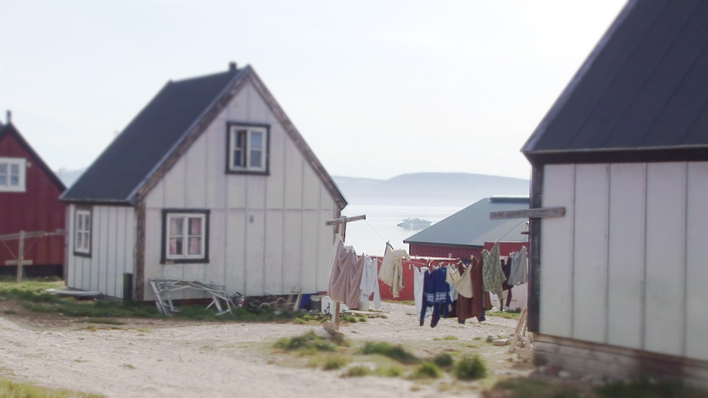 A screenshot of a street in a Greenlandic town showing a house and some washing hanging up to dry